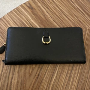 Ralph Lauren plånbok - Svart Ralph lauren med guld detaljer på. Finns plats för 