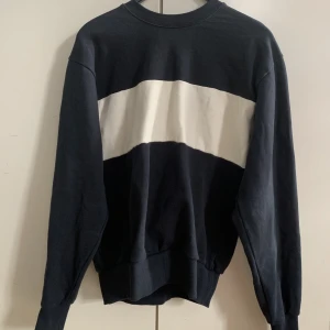 Weekday sweatshirt - Sweatshirt från Weekday. Marinblå med ett horisontellt vitt streck i mitten. Använd endast en gång. Säljer pga inte min stil.