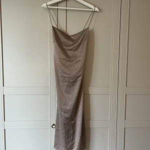Klänning - En superfin klänning i satinmaterial tror jag det är💘den är så fin i ryggen och i champagne mot lila hållet till färg. Skriv vid intresse för fler bilder😊