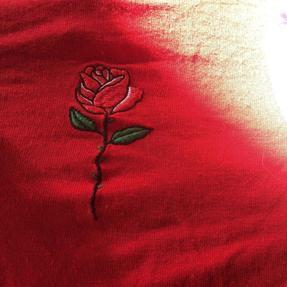 så söt tröja med en broderad ros på men kommer aldrig till användning, den röda färgen är jättefin och tröjan är perfekt croppad, i nyckick . T-shirts.