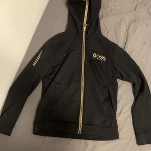 Hugo boss zip upp hoodi  - Jag säljer min Hugo boss zip upp hoodi stl M. Den är fåtal gånger andvänd och den har inga skador. Och den är också äkta.