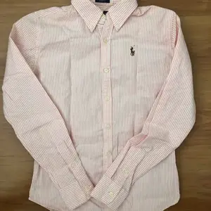 Säljer den här fina Ralph Lauren skjortan som är i nyskick. Den är rosa/vitrandig och är i storlek 0 (slim fit) vilket motsvarar XS. 