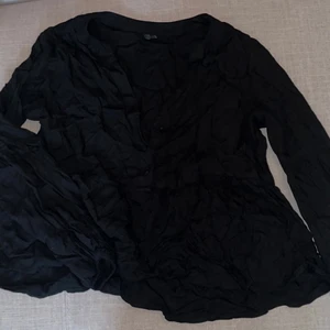 Blus - Svart blus med utsvängd midja