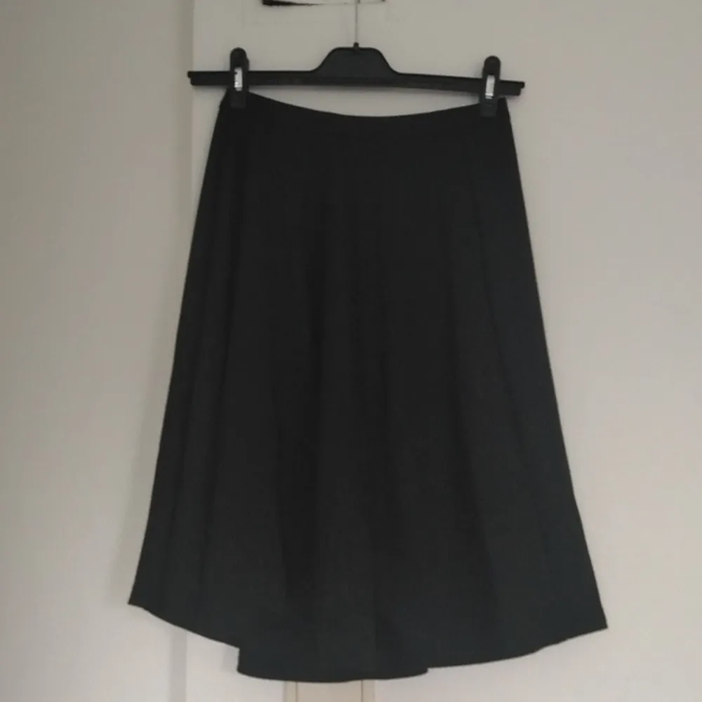 Halvlång svart kjol. Mjukt material dragkedja i rygg, vidform. Storlek small. Kjolar.