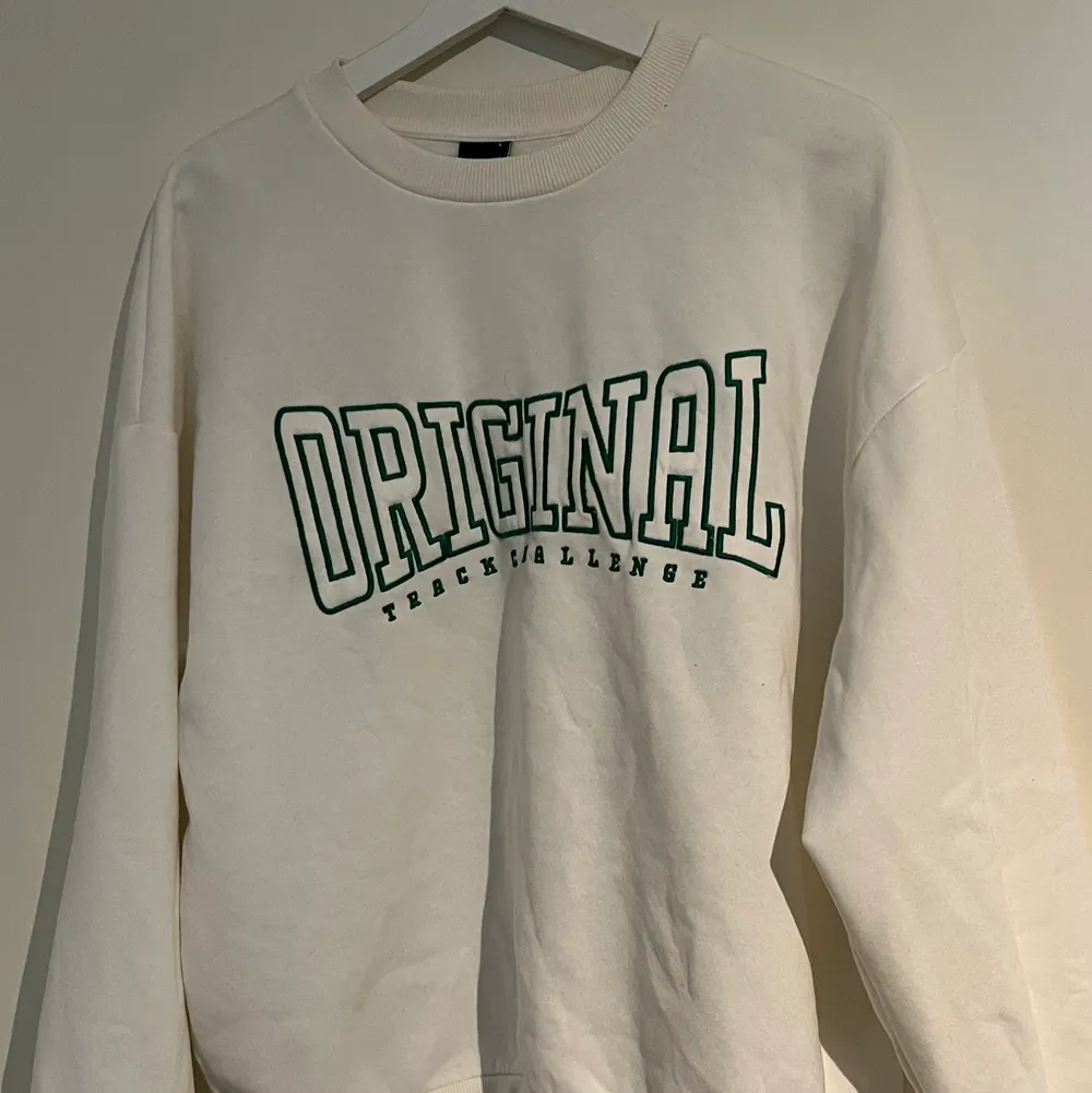 Vit college tröja med en mörk grön text. Aldrig använt . Tröjor & Koftor.