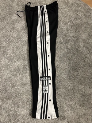Adidas byxor - Jätte snygga Adidasbyxor med knappar Storlek S 