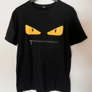 Fendi Bad Bugs t-shirt med zip (Läs Annons!) - Fendi Bad bugs t-shirt med zip. Bra skick, finns en liten fläck på ena ögat (se bild) men inget man tänker på.  Köpt på second hand i Stockholm så tvättlappen är bortklippt och har inget kvitto. Sitter som L Nypris ligger mellan 3000-5000. Kom med bud! 