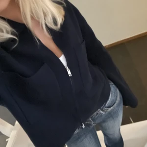 Mörkblå kofta med dragkedja - Säljer denna kofta/ jacka med fickor och dragkedja från Åhléns som har används en gång. Den är i storlek S och är helt slutsåld. 