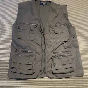 Fiskarväst - Skön fiskarväst i tunnt material. Snygg att slänga på en hoodie. Står xxl i kragen men sitter som M.