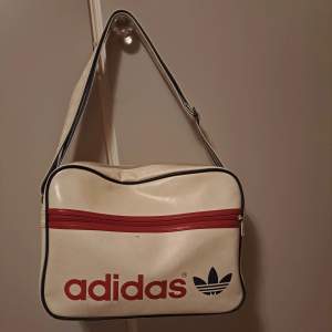 Säljer denna axelremsväska från Intersport med märket adidas för 199kr. Urprungspris 499 kr. Bra skick, men för att se väldigt ny ut behövs tvätt.   Rik på förvaring. Justerbar. Ger 2000-2010 vibbar. (Köpt 2010, 11 eller 12)