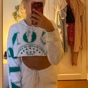 Cropped hoodie - Skit snygg grå cropped hoodie med grönt tryck på framsidan och ärmen. Går att både ha som den är men även med ett linne under.  