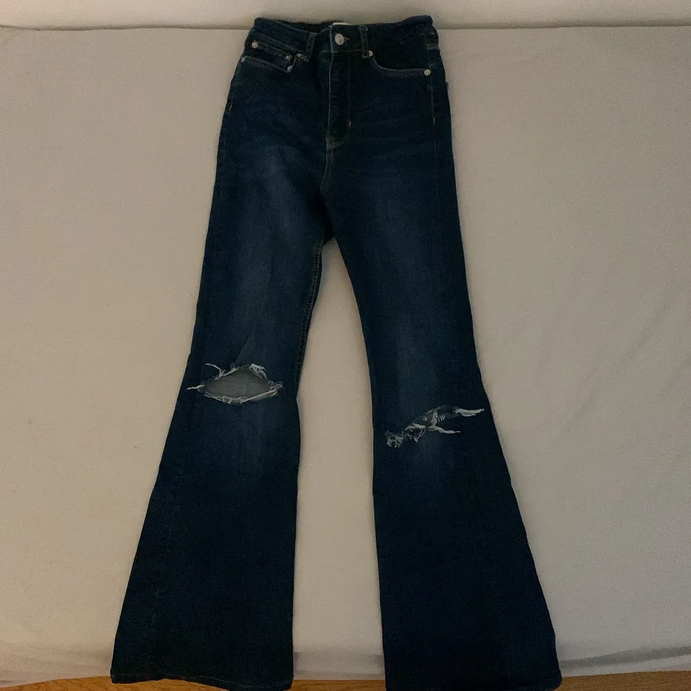Snygga mörkblå Bootcut Jeans med hål på knäna. Strolek 34! Jeansen är från Zara och är uppsydda 3-4 cm💞Finns inga fläckar osv. Utgångspris 150kr, går att buda (:. Jeans & Byxor.