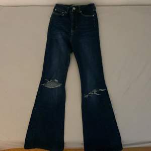 Snygga mörkblå Bootcut Jeans med hål på knäna. Strolek 34! Jeansen är från Zara och är uppsydda 3-4 cm💞Finns inga fläckar osv. Utgångspris 150kr, går att buda (: