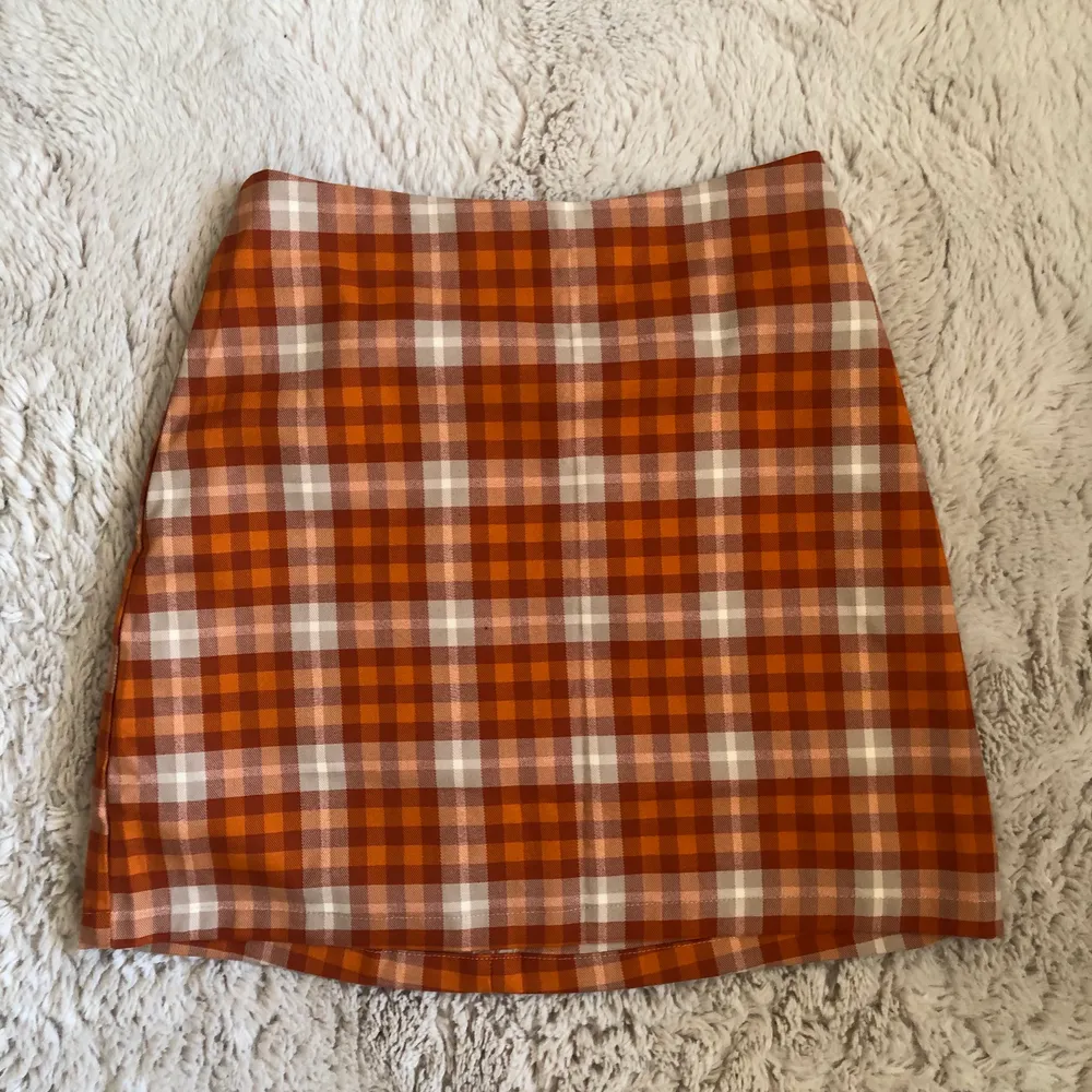 Orange rutig kjol från monki, aldrig andvänd. Köpt för 200kr, säljer för 80kr💋. Kjolar.