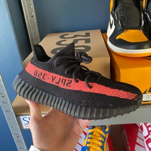 Yeezy 350 Core Black Red - Säljer nu dessa Yeezy 350 Core Black Red som är köpta från Adidas. De är storlek 40 2/3 Eu och helt nya och oanvända, hör av dig vid frågor eller i behov av fler bilder