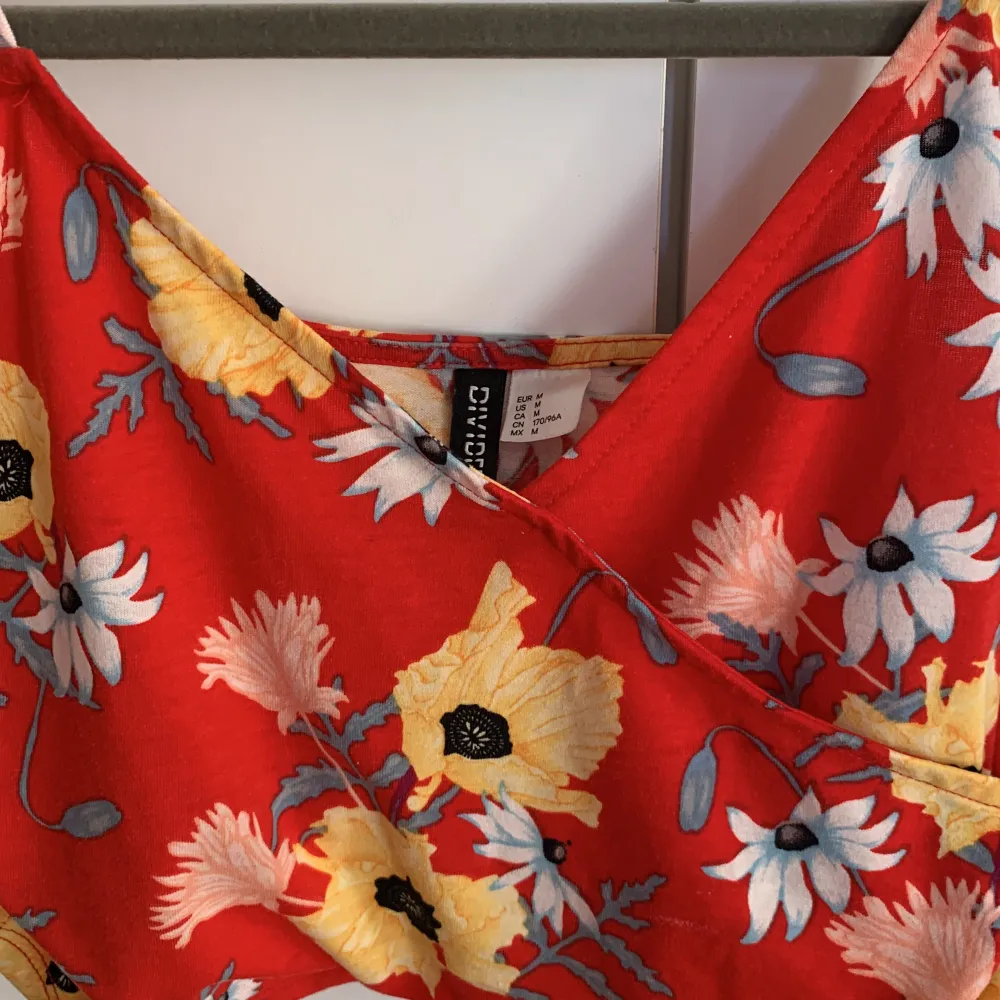 Ett kort blommigt linne från H&M Divided. Säljes då det ej kommer till användning :). Toppar.