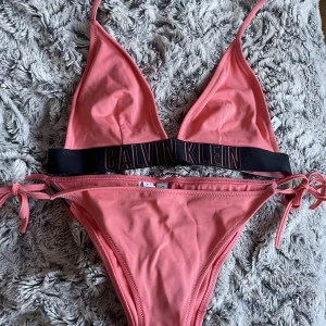 Bikini från Calvin Klein🤍 - Tryck gärna på ”KÖP NU”. Rosa-orange bikini från Calvin Klein som bara använts ett par gånger 🧡💗 (andra bilden visar underdelen bakifrån). Supersnygg när man är brun! Båda delarna är i storlek S❤️🧡