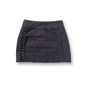 Kort kjol med korsettsnörning - Använd med fint skick! Midja: 67,5cm Längd: 34,5cm  Dragkedja bak samt snörning på båda sidor (går ej att öppna).