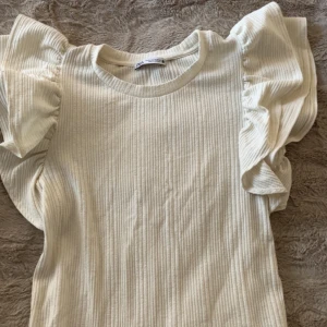 Volang t-shirt - Sälje min t-shirt från zara med volang på ärmarna. Den är köpt i somras och är i storlek m men sitter precis som en s. Använt sparsamt. Säljer pågrund av att den inte kommer till användning längre.
