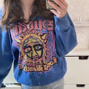 Zipup hoodie med tryck - Blå tröja med färgglatt tryck. Storlek M och lite oversized i storleken.