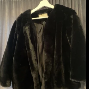Pälsjacka  - En svart skön pälsjacka (fake), perfekt till våren. Tyvärr ett litet hål i ena fickan fanns när jag köpte den, annars i nyskick knappt använd. Storlek 42 passar 38.