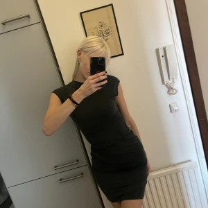 Mörkgrön Klänning - Mörkgrön klänning, veckad i höfterna 