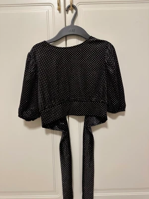 Siden glittrig kort topp med öppen rygg - Snygg glittrig topp, aldrig kommit till användning alltså helt nytt skick. 