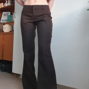 Bruna lågmidjade byxor strl 36 - Lågmidjade bruna kostymbyxor som är utsvängda i storlek 36! Köpta någon gång i början på 2000talet men i bra skick! höftmåttet är 80cm och benlängden 81 cm<3