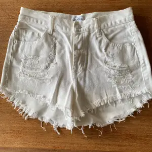 Vita slitna jeansshorts i stl. M men kan användas som något löst sittande för stl. S. Köpta på Nelly använda ett fåtal gånger.