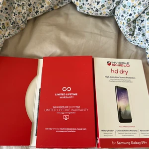 Invisible Shield (Samsung Galaxy S9+) - Invisible Shield är ett jättebra skärmskydd. Allt som ska finnas i förpackningen visas på bilden och de ligger i deras förpackning. Har inte behövt den till slut. 