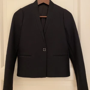 J.Lindeberg blazer, dam strl 34, oanvänd - Säljer en oanvänd blazer/kavaj från J.Lindeberg i strl 34. Den är i croppad modell med en knapp fram. Passar både till en mer dressad look och en mer avslappnad look med ett par jeans. 