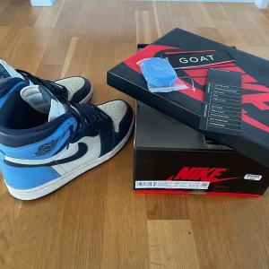 Jordan 1 obsidian  - Skick 9/10, skriv om ni har några frågor. Skorna är strlk 43, och köpte på GOAT. Allt på bilden medföljer. 
