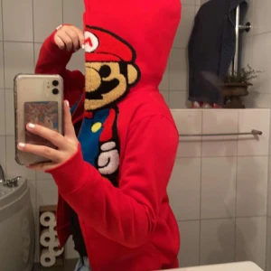 Mario baby milo hoddie  - Säljer min mario baby milo hoddie då den aldrig kommer till användning, helt ny, bra tjockt material, full zip och trycket är mjukt. Storlek S men är som en s/xs, skriv för mer bilder.