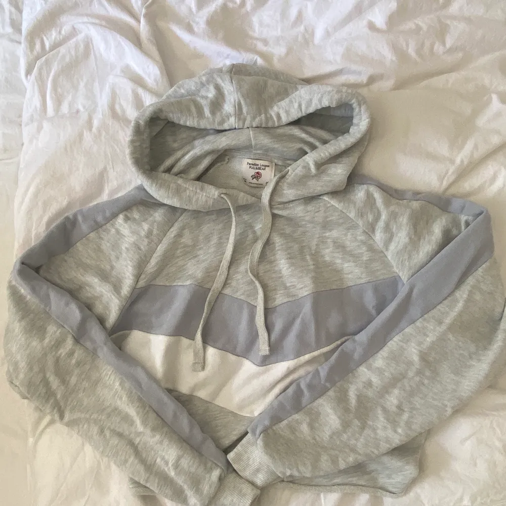 Croppad Pull&Bear hoodie i färgen grå med blå/lila och vita ränder. Strlk M, är som en oversized small typ. . Hoodies.