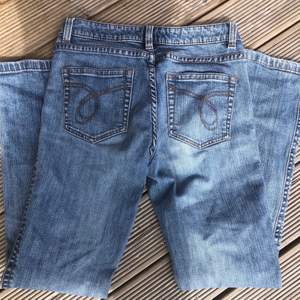 Ett par blåa jeans med detaljer på fickorna. Fint skick och köpt secend hand.