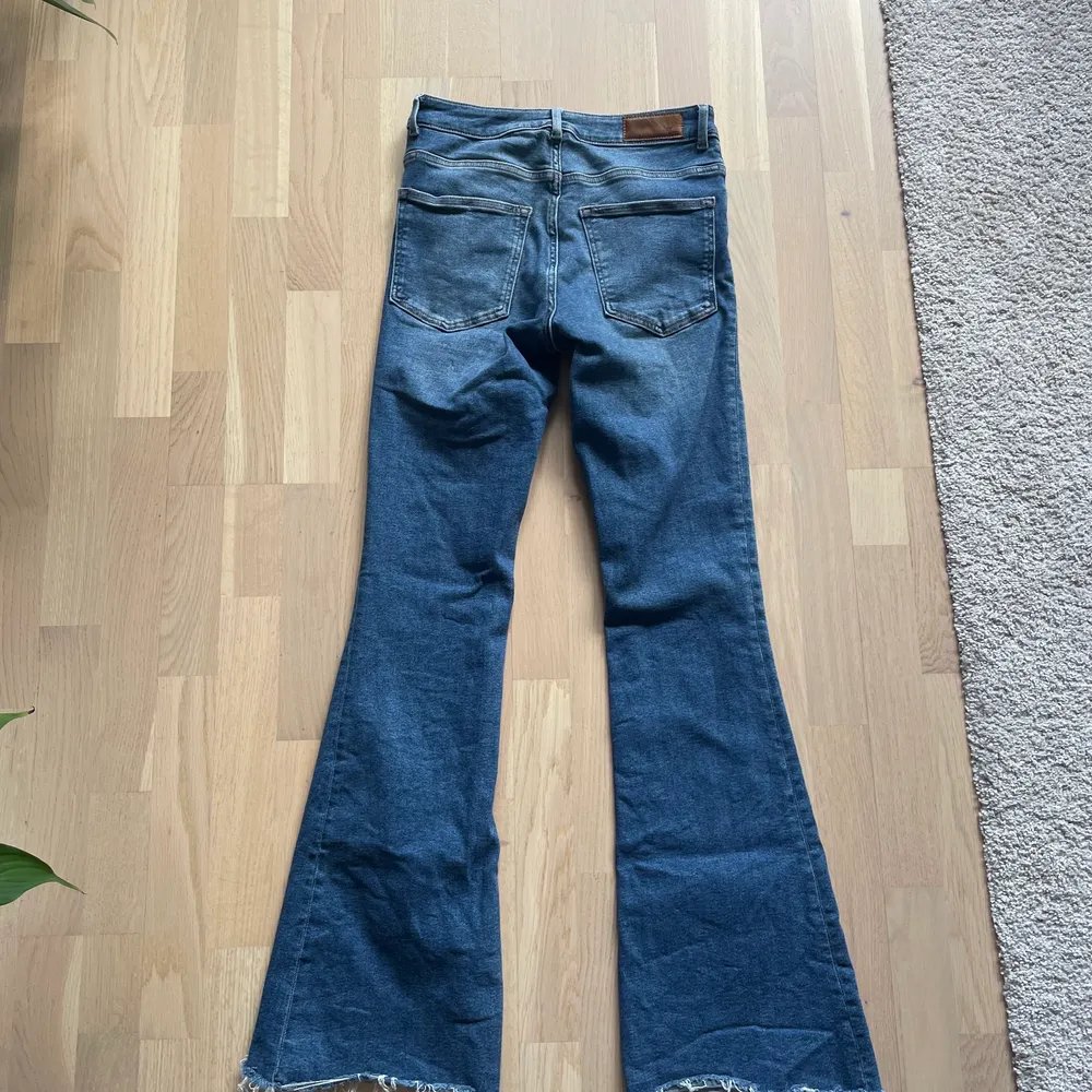 Blåa lite ”blekta” utsvängda jeans från BikBok. Storlek M. Jeans & Byxor.