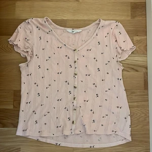 Rosa T-shirt med svarta blommor  - En rosa t-shirt med svarta blommor på från H&M  Storlek: 158/164