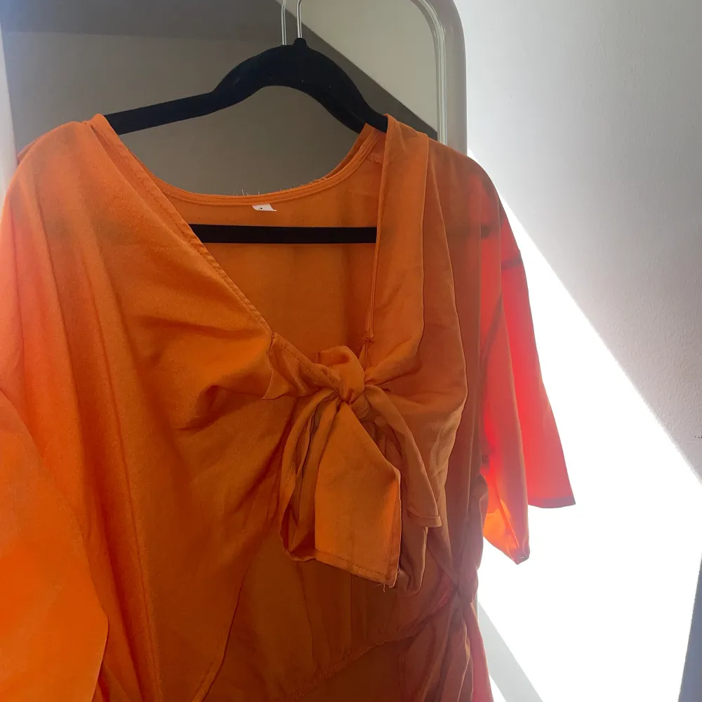 Orange klänning med en öppning vid magen, anvönd 1 gång. Pris kan diskuteras vid snabb affär❤️. Klänningar.
