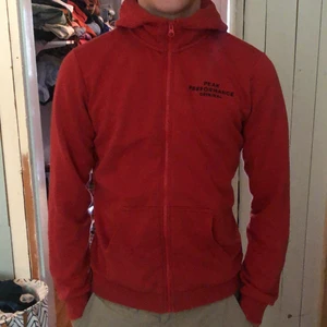 Röd Peak Performance zip hoodie  - Säljer en röd peak performance zip up hoodie i storlek 170/ S  Den kostar 599 ny 