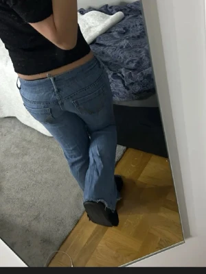 Blå bootcut jeans från Hollister - Säljer ett par klassiska blå jeans från Hollister med bootcut passform. Jeansen har stretch, snygga bakfickor med dekorativa sömmar och låg midja. Perfekta för dig som gillar en avslappnad men ändå trendig look.