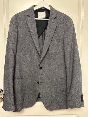 Grå kavaj från Studio Total - Snygg grå kavaj från Studio Total med klassisk passform och två knappar framtill.