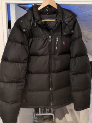 Ralph Lauren jacka  - Säljer min Ralph Lauren jacka då jag har 2 stycken,denna är i XL skulle säga att den passar xxl också om man gillar den lite mer Slim fit. En pytteliten skade bak på ryggen och framme vid vänster ficka men det är inget man ser så bra,säker lätt att ba sy ihop☺️ inga andra konstigheter ska de va på den hör av er vid funderingar!! Mvh Elias...