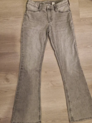 Grå bootcut jeans med utsvängda ben - Snygga grå jeans med bootcut-modell och utsvängda ben. Använd några få gånger men inte några fläckar på. Storlek cirka 150