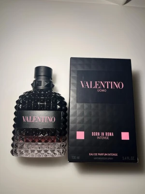 Valentino Uomo Born In Roma Intense 100ml - Lyxig parfym från Valentino, Born In Roma Intense, 100ml. Flaskan är robust med nitar och svart kork, och har en mörk, elegant design med rosa detaljer. Doften är intensiv och passar dig som vill sticka ut med en modern och självsäker stil.