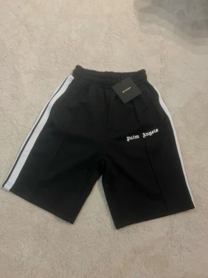 Palm angels och Essentials shorts - Snygga och trendiga shorts från Palm Angels. Perfekta för sommar och streetlooks.