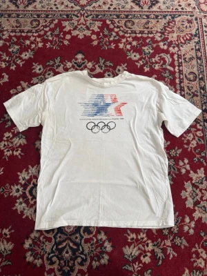 Os t-shirt - Riktigt najs T-shirt med motiv från OS i Los Angles 1984. Inköpt i USA. Väldigt bra skick knappt använd. Kan slänga in gratis vid köp av jeans. 