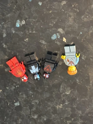 Fyra LEGO-figurer blandade teman - Säljer fyra LEGO-minifigurer med olika teman. En figur är röd med tryck, två är svarta med detaljerade dräkter och en är grå med orange hår och tryck på överkroppen. Perfekt till samlingen eller för att bygga egna äventyr jag säljer alla för 300 sen styck tar man vid förhandling 