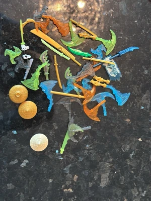 Lego vapen och sköldar mix - Blandat set med Lego-vapen och sköldar i olika färger som grön, blå, orange och guld. Innehåller svärd, yxor, spjut och tre runda sköldar. Perfekt för att bygga egna figurer eller utöka din samling av Lego-tillbehör säljer alla för 200 sen styck kan man förhandla då
