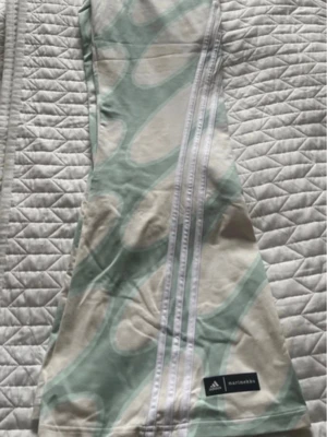 Adidas X Marimekko Future Icons Flared - M - Nya/oanvända. Tight fit Elastic waist 90% cotton, 10% elastane single jersey Mid rise Köpt hos Stadium Storlek Medium