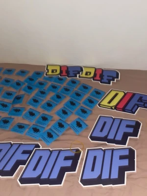DIF klistermärken och stickers - Stort paket med DIF klistermärken och stickers i olika former och färger. De flesta är blå med svart motiv och text, samt några större stickers med DIF-logga i blått, gult och rött. Materialet är papper och plast, perfekt för att pimpa prylar eller accessoarer.